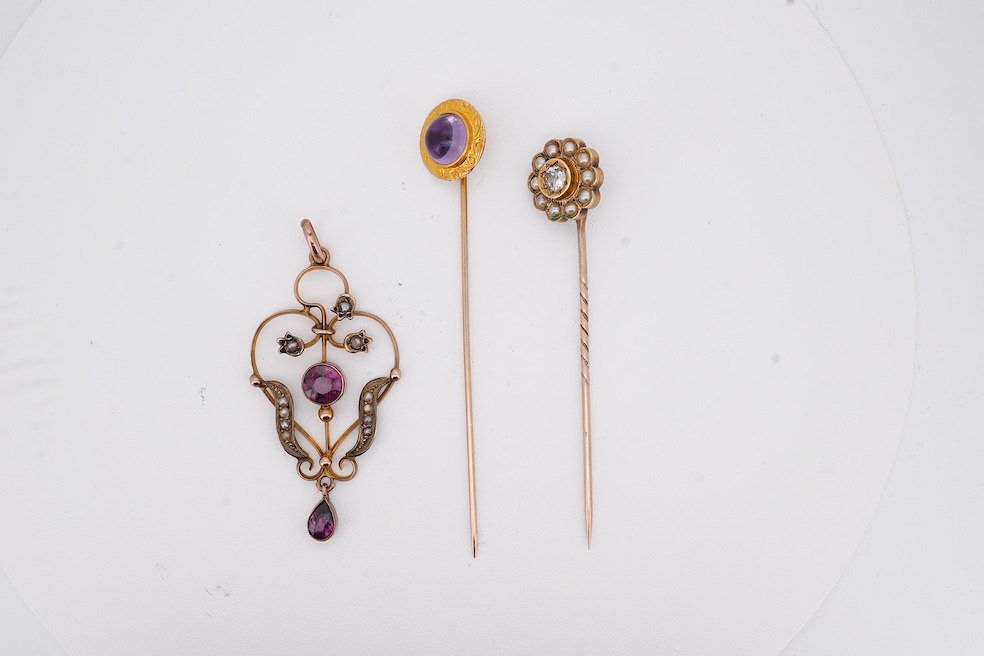 An Edwardian 15ct, diamond and seed pearl cluster set stick pin, 54mm, a similar yellow metal and cabochon garnet set stick pin and an Edwardian 9ct and gem set drop pendant. Condition - poor to fair